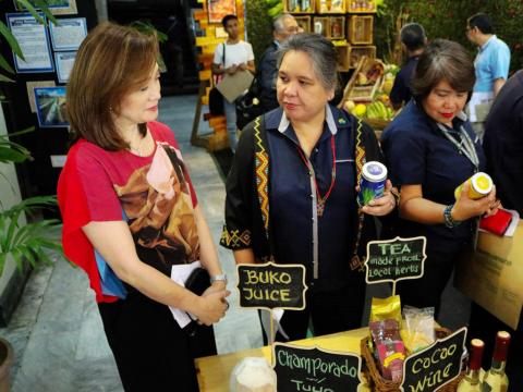 Philippine Culinary Heritage Movement member Nina Daza Puyat and Agribusiness and Marketing Assistance Service Director Bernadette San Juan sample Tsaa Laya at Filipino Food Month event